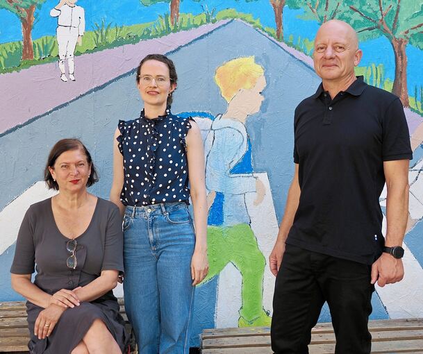 Heike Gross, Abteilungsleiterin in der Kunstschule Labyrinth, Katrin Kulik von der Stadtverwaltung (Mitte) und Jochen Raithel, Leiter der Kunstschule Labyrinth, vor einem der von Kindern gemalten Bildern.