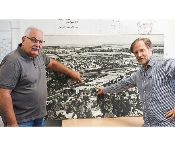 Thomas Wörner (links) und Andreas Ivenz zeigen auf einem Wandfoto auf den Standort des Unternehmens Kienle+Spiess. Das Foto stammt von Ende 1970er oder Anfang der 1980er Jahre, sagen die beiden.