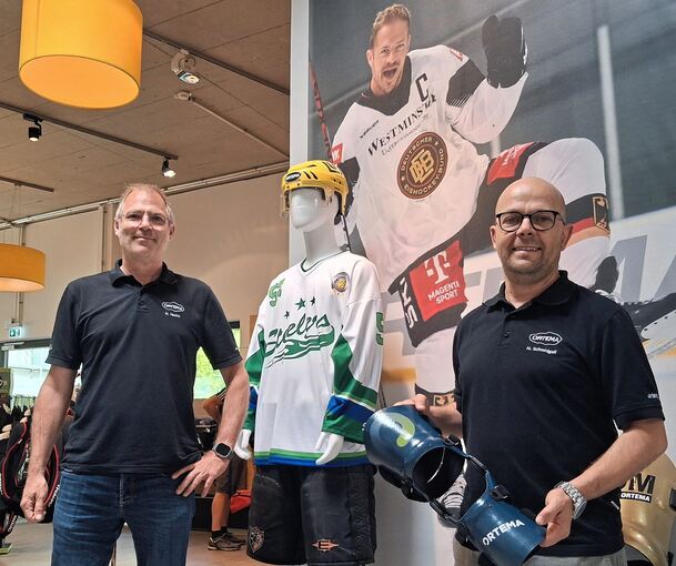 Zwei Heikos und ein Moritz: Heiko Hecht (links) und Heiko Schmidgall (mit Knieorthese) stehen in den Ortema-Räumen vor einem Bild des Eishockey-Profis Moritz Müller.