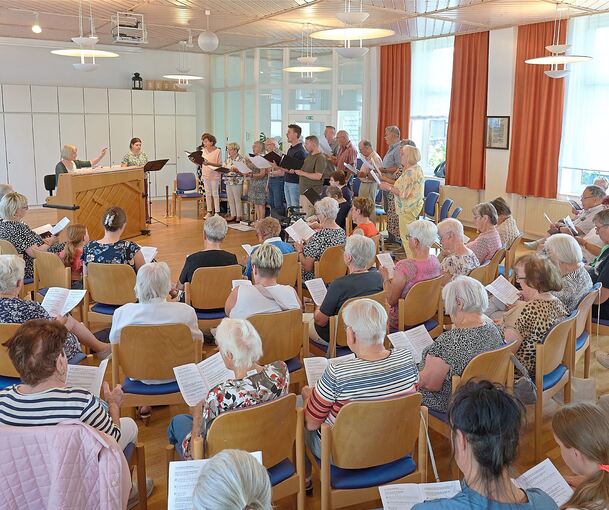 Rund 50 Besucher sind der Einladung gefolgt und füllen den Saal in halbrunder Bestuhlung nahezu vollständig.