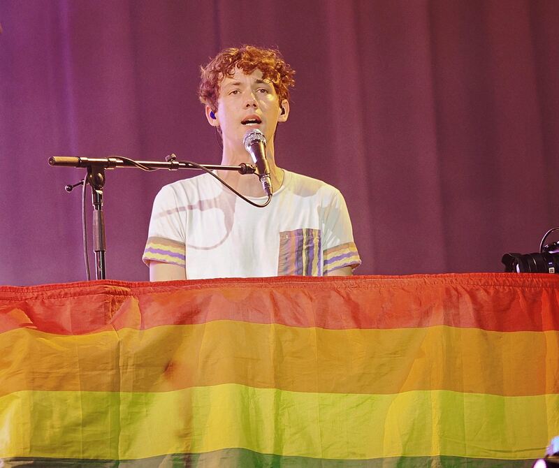 Henning May verschwindet an sein Keyboard hinter einer LGBTQ-Flagge.