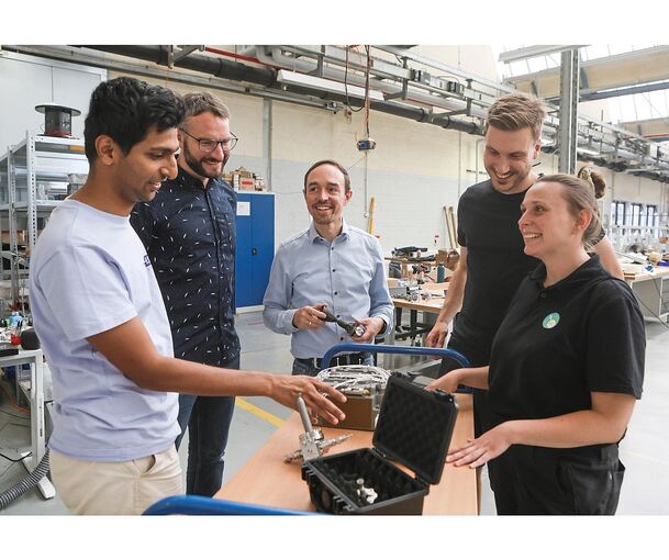 In der Mitte steht einer der beiden Firmengründer, um ihn herum Mitarbeiter: (von links) Taha Merchant, Philipp Altenhöfer, Lukas Werling, Moritz vom Schemm und Sonja Hofmann in einer der Hallen, in der früher Mann+Hummel produzierte und heute ISPTec