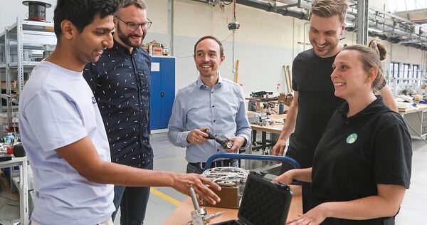 In der Mitte steht einer der beiden Firmengründer, um ihn herum Mitarbeiter: (von links) Taha Merchant, Philipp Altenhöfer, Lukas Werling, Moritz vom Schemm und Sonja Hofmann in einer der Hallen, in der früher Mann+Hummel produzierte und heute ISPTec