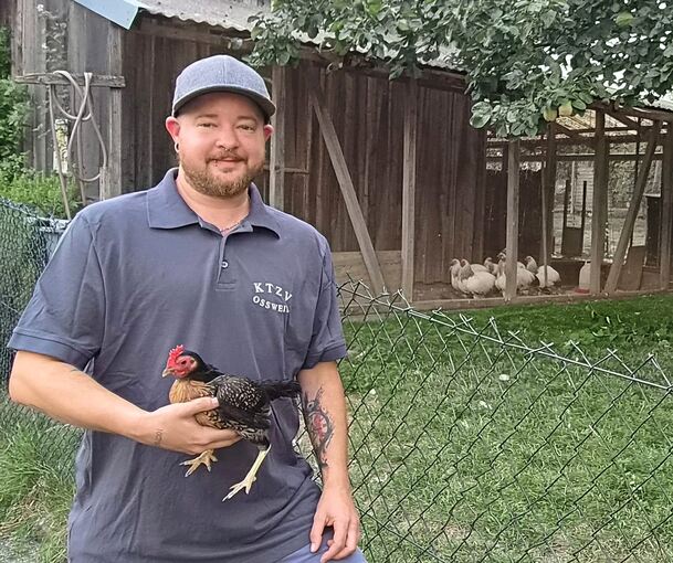 Der Vorsitzende des Oßweiler Kleintierzuchtvereins, Moritz Höllwart, hält eines seiner Altenglischen Zwergkämpfer in der Hand.