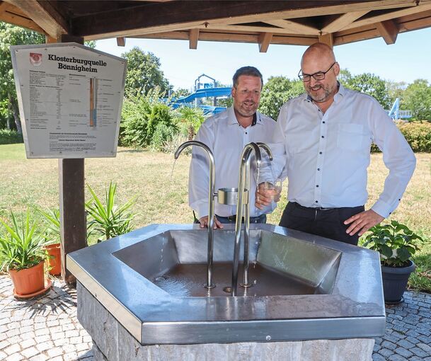 Schwimmbadleiter Björn Beal, und Kämmerer German Thüry vor dem eigenen Trinkwasserbrunnen im Mineralfreibad.