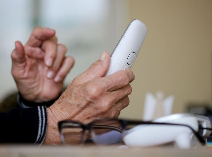 Rentner hält Telefon in der Hand