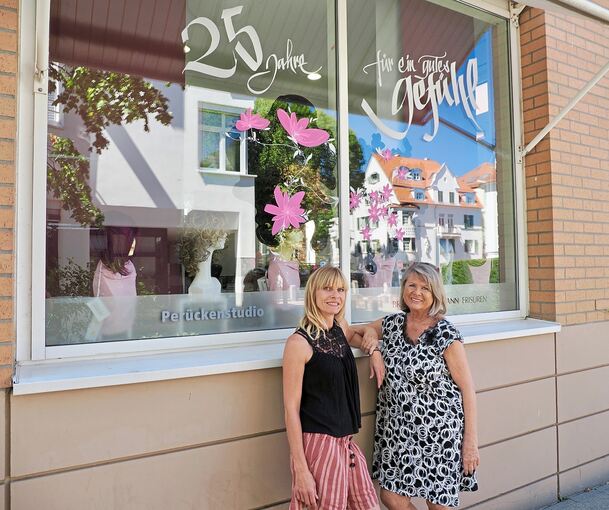 Brigitte Hartmann (rechts) und ihre Tochter Iris Reale vor ihrem Friseursalon am Ludwigsburger Solitudeplatz. „25 Jahre für ein gutes Gefühl“ steht auf dem Schaufenster.