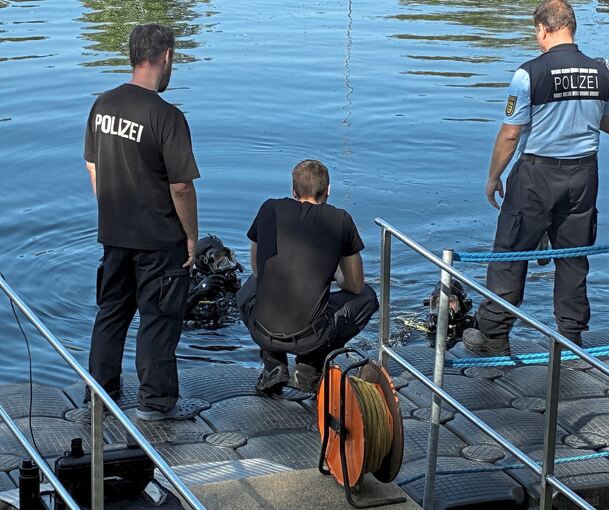 Polizeitaucher stiegen in den Fluss.