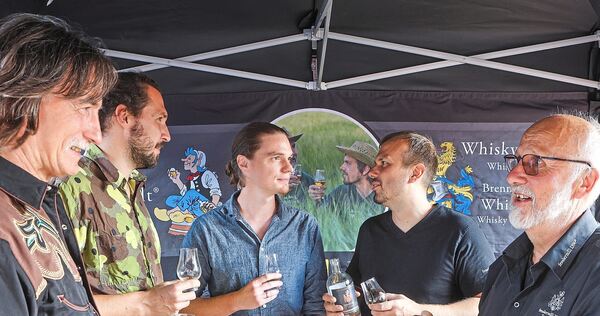 Wolfgang Fessler (rechts) und sein Sohn Tobias Fessler (links neben ihm) fachsimpeln mit den Gästen über Whisky. In der Fessler-Mühle gab es aber nicht nur Destillate aus dem eigenen Haus zu verkosten.
