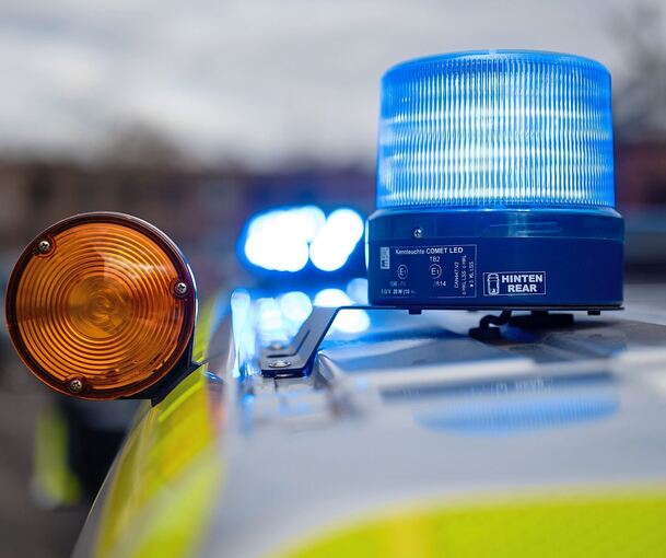 Ein Polizeifahrzeug mit eingeschaltetem Blaulicht. Ein Polizeifahrzeug mit eingeschaltetem Blaulicht.