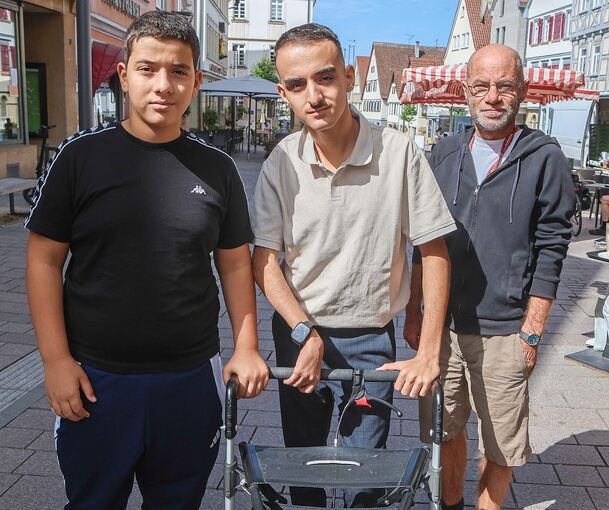 Aziz Soya (Mitte) erhält nicht nur von seinem Rollator Hilfestellung. Bruder Mahmut und Lehrer Jens Frölich setzen sich für den Schüler ein.