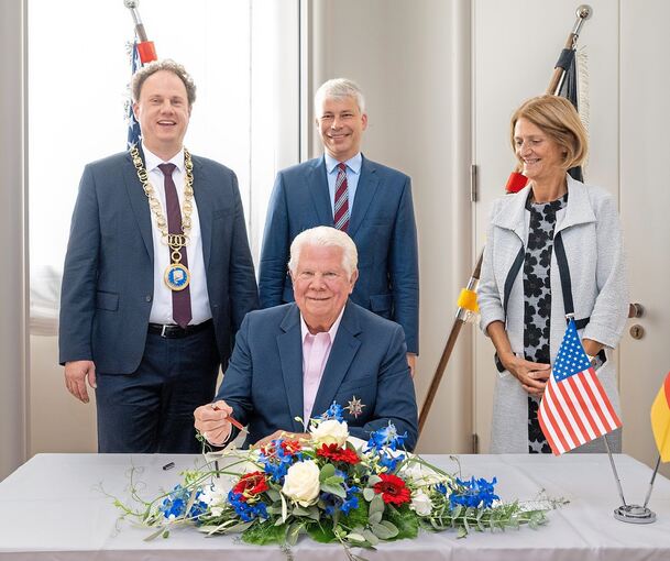 Eintrag ins Goldene Buch der Stadt: Der Bürgermeister von Saint Charles, Dan Borgmeyer (vorn), mit Oberbürgermeister Matthias Knecht, dem Bundestagsabgeordneten und Verkehrsminister Steffen Bilger sowie Marie-Noelle Biguinet, der Bürgermeisterin von