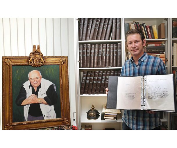 Marc-Oliver Boger vor den von Gerd Heidemann kopierten und übersetzten Hitler-Tagebüchern im Kujau-Kabinett. Kujau selbst steuert ein Selbstporträt bei.