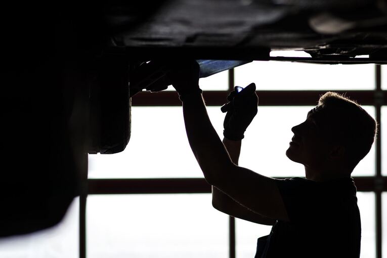 Ein Mechaniker begutachtet ein Auto in einer Werkstatt