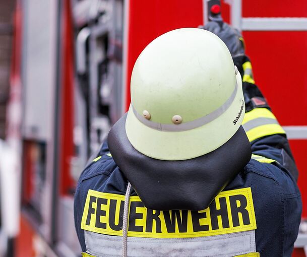 Ein Feuerwehrmann holt eine Leiter vom Einsatzfahrzeug. Ein Feuerwehrmann holt eine Leiter vom Einsatzfahrzeug.