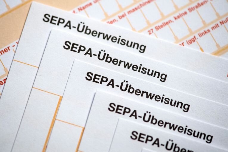 SEPA-Überweisungsscheine liegen auf einem Tisch SEPA-Überweisungsscheine liegen auf einem Tisch