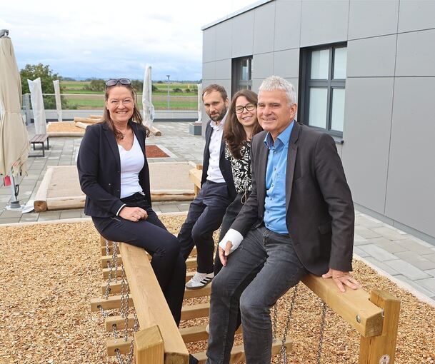 Kita-Leiterin Anne Kuhlmann (links), das Team von Littlebig Future und der Bürgermeister Holger Albrich (rechts) im Outdoor-Bereich der Kita.