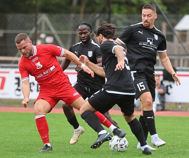 Drei Besigheimer Spieler (in Schwarz) wollen es dem Gegner aus Hessigheim schwer machen.