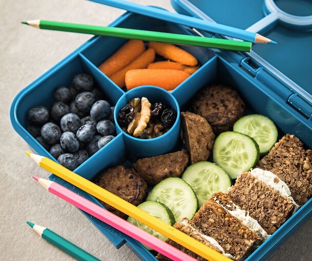 Obst, Gemüse, Vollkornbrot und Nüsse sind ideale Pausensnacks. Mit den richtigen, schnellen Rezepten lässt sich Abwechslung in die Lunchbox bringen.