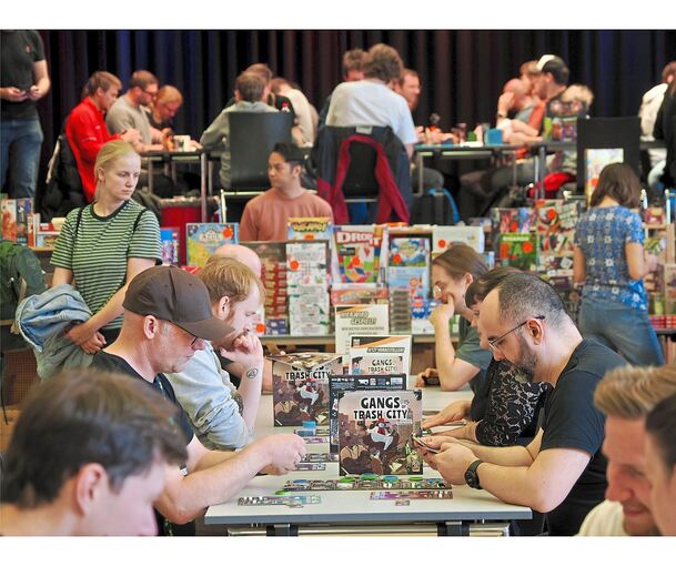 Besucher können sich am Verlagsstand Spiele ausleihen und an den Tischen in der Saalmitte testen. Das Angebot stößt auf große Nachfrage.