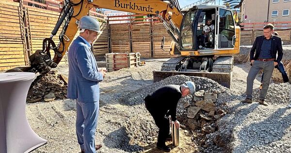 Bietigheimer-Wohnbau-Geschäftsführer Carsten Schüler und Oberbürgermeister Jürgen Kessing versenken die Zeitkapsel unter der künftigen Tiefgarage.