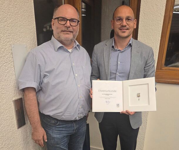 Bürgermeister Robert Feil (rechts) überreicht Robert Fiesel die Ehrenurkunde des Gemeindetages Baden-Württemberg.