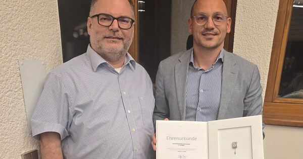 Bürgermeister Robert Feil (rechts) überreicht Robert Fiesel die Ehrenurkunde des Gemeindetages Baden-Württemberg.