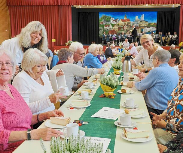 An der gedeckten Kaffeetafel nehmen zahlreiche Senioren Platz.