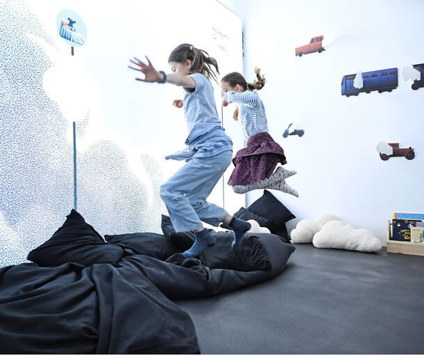 Mit Schwung in die Kissen: Ida (links) und Betty haben bei der Ausstellung viel Spaß.